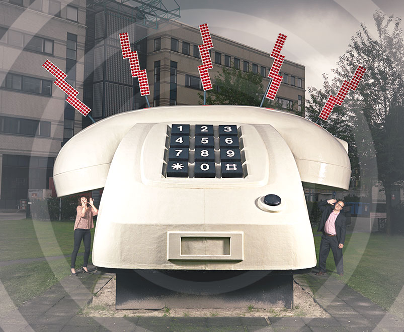 two people next to large telephone